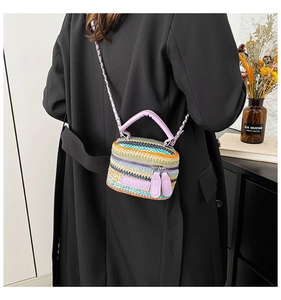 Dettaglio ravvicinato di borsa a secchiello intrecciata colorata con manico viola
