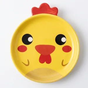 Detail view of yellow round paper plate featuring a cute cartoon chicken for birthday parties