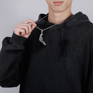 Detailed view of vintage punk style silver pistol pendant on a twisted rope chain