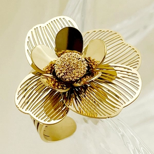 Detailed macro shot of a golden floral ring featuring intricate hollow mesh petals