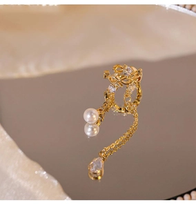 Detail of gold-plated tassel ear cuff with sparkling zircons and a round pearl drop