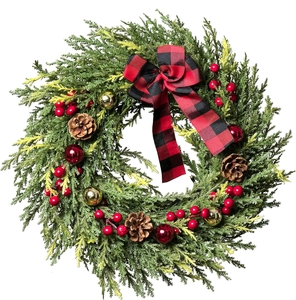 Detailed view of artificial Christmas wreath with red berries, pine cones and plaid bow