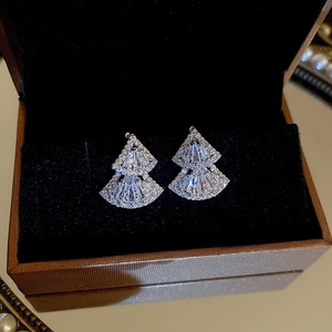 Macro shot of silver fan-shaped earrings with zircon pavé on black velvet lining