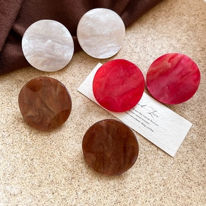 Close-up of marble texture acrylic earrings in red and brown colors with a vintage feel