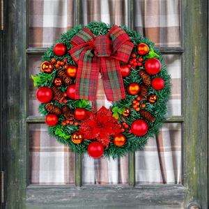 Christmas wreath with red plaid bow, pine cones, and festive ornaments on a green door