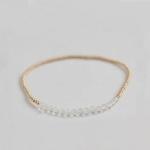 Detailed top view of a delicate amethyst beaded bracelet with polished golden metal accents