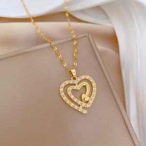 Elegant gold titanium heart necklace with triple layered crystals on a soft silk background