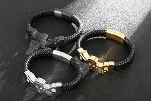 Close-up of woven leather men's bracelets with metallic skulls in black, gold, and silver