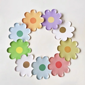 Macro detail of colorful daisy shaped paper plates in a circular layout for parties