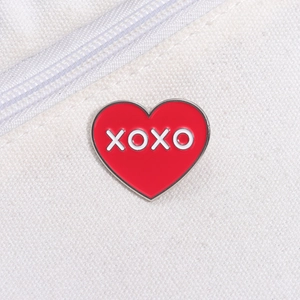 Épingle créative en émail cœur rouge avec lettrage XOXO blanc sur toile blanche