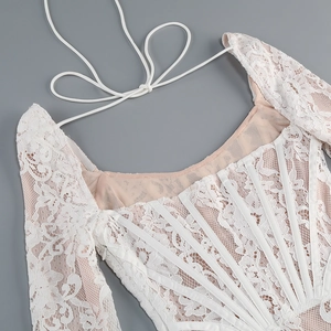 Détails de la robe en dentelle blanche avec baleines de corset et motifs floraux