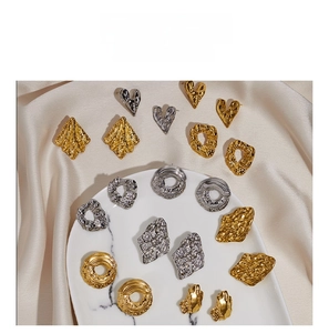 Detail of vintage textured geometric earrings in gold and silver with hammer finish