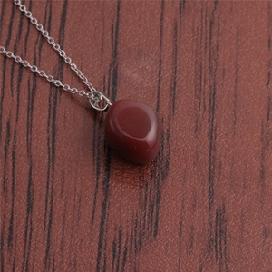 Close-up of a polished red-brown tiger eye stone pendant on a silver-tone chain