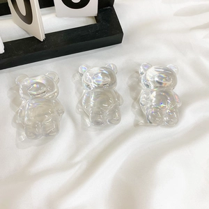 Close-up of three iridescent laser-coated bear charms with vibrant rainbow reflections