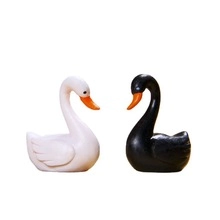 Detail of elegant black and white swan figurines with smooth polished resin finish