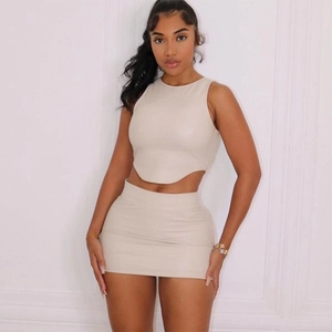 Completo chic in pelle PU beige con crop top senza maniche e minigonna aderente alla moda