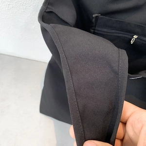 Détail d'un sac en toile noire avec poche intérieure zippée en métal et bords renforcés