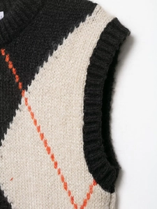 Close-up of diamond pattern knit vest with orange stitching and ribbed edges