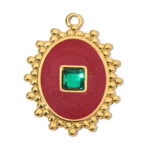 Macro view of vintage gold eagle pendant with red enamel and green stone inlay