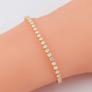 Detailed view of a gold-plated tennis bracelet with shimmering cubic zirconia crystals
