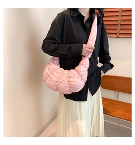 Model wearing a pink pleated dumpling bag showing the stylish oversized ruched texture