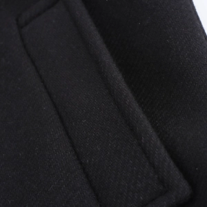 Close-up detail of high-quality black wool blend fabric texture and stitching on coat