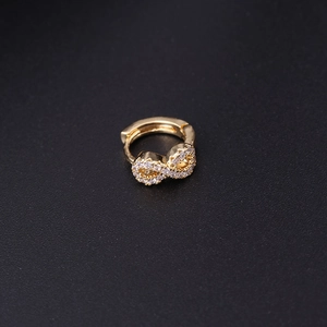 Macro shot of gold infinity hoop earring with sparkling cubic zirconia on black background