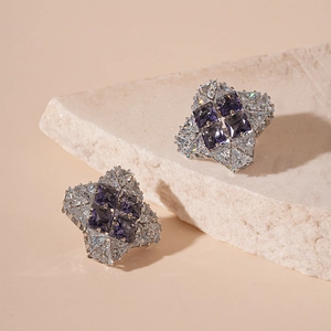 Elegant silver star studs with purple zircon gems and crystals on a white stone