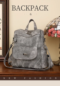 Detail eines grauen Vintage-Rucksacks mit gewaschener Ledertextur auf einem Holztisch