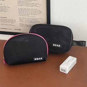 Macro detail of breathable black mesh makeup bags with pink zippers and BEAR logo