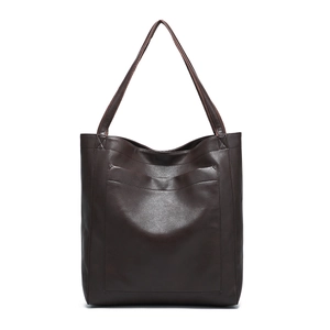 Gros plan sur la texture en cuir vintage marron foncé et la poche de ce sac cabas