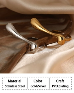 Macro detail of gold and silver irregular water drop rings on soft white satin fabric