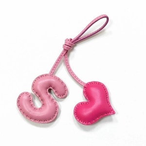 Detailed close-up of pink PU leather letter S and heart keychain with neat stitching