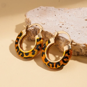 Elegant 14k gold plated leopard print hoop earrings on a natural stone background