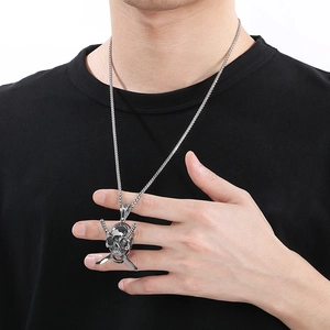 Close-up of punk style skull and cross swords pendant on a silver steel chain for men