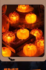 Close-up of LED glowing orange pumpkin lanterns scattered on vintage books for decoration