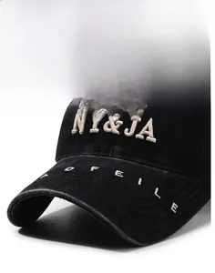 Macro detail of NY&JA embroidery and stiff brim on washed black vintage baseball cap
