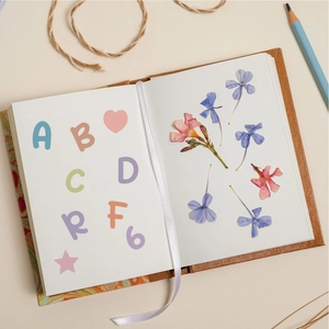 Detail of 0.5 inch colorful alphabet stickers and dried flowers on a journal page