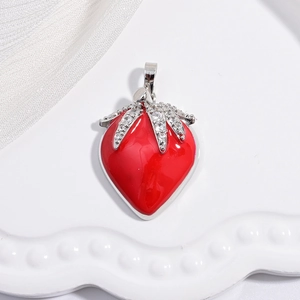 Macro shot of red strawberry pendant with silver leaves and sparkling zircon details