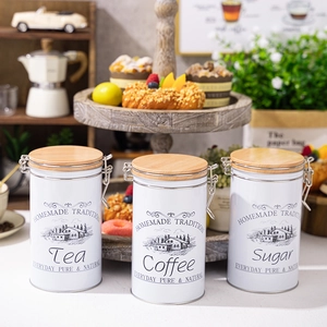 Three white kitchen storage canisters for tea coffee and sugar with wooden airtight lids