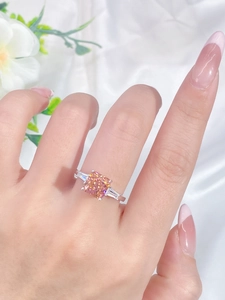 Detailed close-up of a square pink padparadscha sapphire silver ring on white silk
