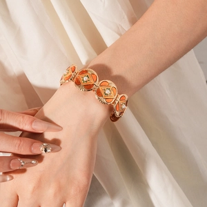 Detailed macro view of vintage gold-plated wide cuff with orange enamel and pearls