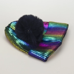 Dettaglio del berretto in maglia arcobaleno con un soffice pompon di pelliccia sintetica