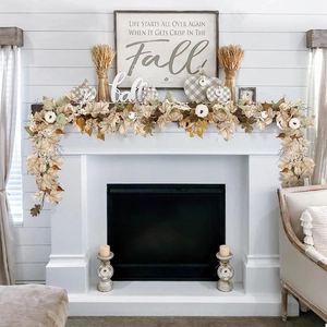 Thanksgiving autumn garland with white pumpkins and maple leaves on a fireplace mantle