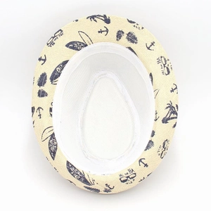 Macro detail of breathable straw sun hat featuring navy anchor and palm leaf patterns