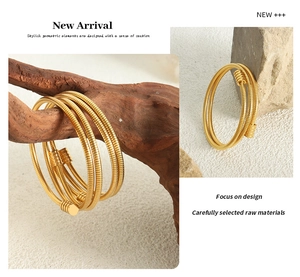 Close-up of gold-plated snake bone multilayer bracelet wrapped on a natural wood branch