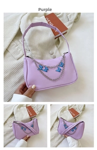 Detail of purple faux leather bag with silver chains and blue butterfly charms