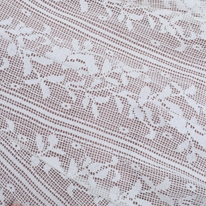 Gros plan sur le tissu en dentelle blanche aux motifs floraux et géométriques