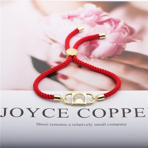 Adjustable red woven cord bracelet with gold crescent moon pendant and zircon inlay