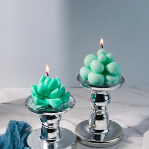 Detailed view of green succulent and bubble shaped candles on vintage silver holders